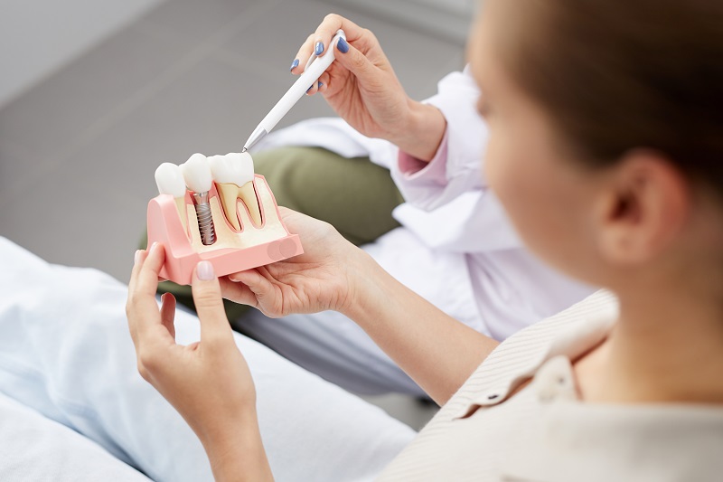 Calgary patient holding dental implant model