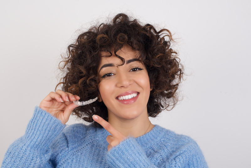 Woman holding clear aligner tray