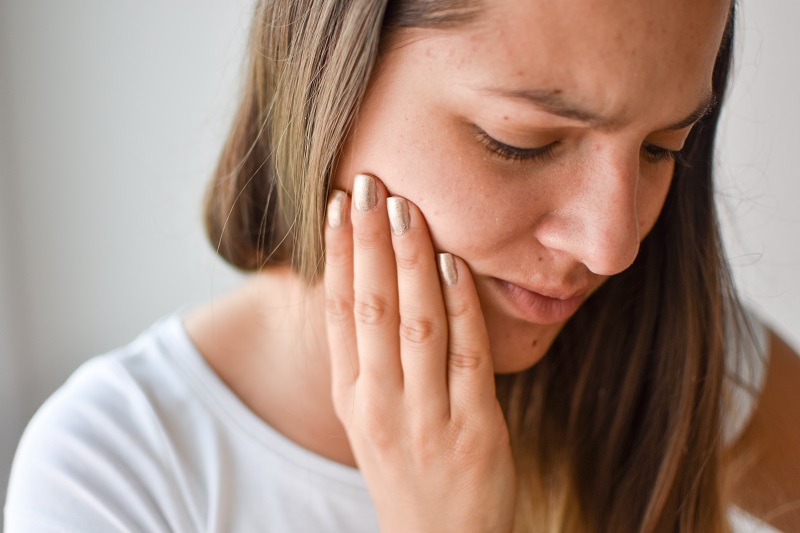 Woman experiencing TMJ pain in Calgary 