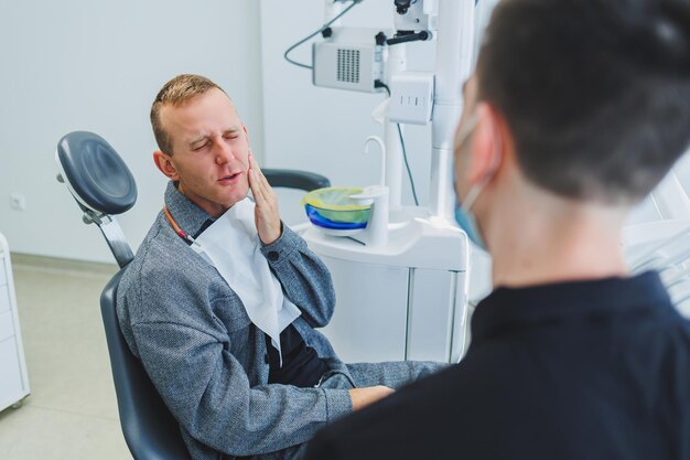 young-dentist-doctor-tells-male-patient-about-dental-care-man-was-sitting-dental-chair-doctor-s-appointment-modern-dental-treatment
